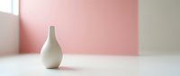 Minimalist white ceramic vase on clean surface against soft pink and beige background for modern home decor and interior design projects.
