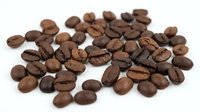 Roasted coffee beans scattered on white background, isolated for cafe menu design, beverage branding and culinary projects.