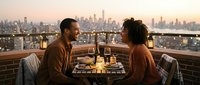 African American couple enjoying romantic dinner on rooftop terrace with city skyline at sunset, perfect for dating apps and relationship content.