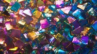 Colorful iridescent confetti pieces scattered creating vibrant rainbow metallic texture for celebration party decoration background.
