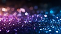 Magical glowing bokeh lights creating dreamy abstract background with purple and blue gradient colors, sparkling particles scattered across dark surface.
