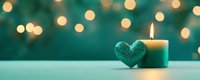 Turquoise candle burning beside sparkling heart decoration with warm bokeh lights creating romantic holiday atmosphere for celebrations and special occasions.