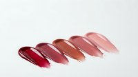 Glossy lipstick swatches in red pink nude tones on white background for cosmetic beauty makeup product advertising and branding materials.