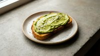 Fresh avocado toast on artisan bread served on ceramic plate, healthy breakfast meal with green superfood spread and seeds for nutritious eating lifestyle.