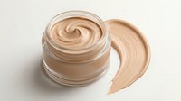 Creamy beige foundation makeup in open glass jar with smooth swirl texture and color swatch, cosmetic product for skincare and beauty routine on neutral background.
