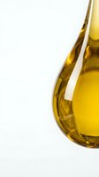 Golden olive oil in glass bottle isolated on white background, suitable for food, cooking, and culinary design projects.