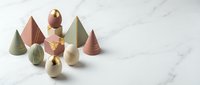 Minimalist geometric wooden toys in pastel colors arranged on white marble surface for modern nursery decor and educational play activities.
