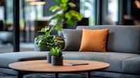 Modern living room interior with gray sofa, orange accent pillow, wooden coffee table and potted plants creating cozy atmosphere for home or office space.