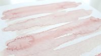 Soft pink watercolor brush strokes on white paper creating gentle abstract texture for artistic backgrounds and creative design projects.