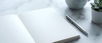 Blank notebook with pen on marble desk workspace with succulent plant and ceramic pot, ready for writing or design mockup.