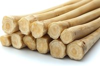 Bundle of natural bamboo canes stacked together on white background, eco-friendly construction material for garden support and sustainable building projects.