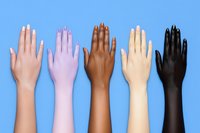 Diverse female hands with manicured nails raised against blue background showing unity, diversity, and inclusion concept in modern minimal style.