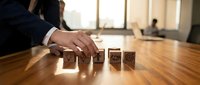 Professional businessman arranging wooden blocks with contact icons on office desk. Business communication and customer service concept for marketing.