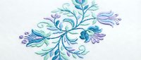Elegant floral embroidery design with swirling leaves and decorative elements in blue and purple thread on white fabric for textile crafts.