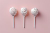 White lollipops arranged in row on pink background, minimalist candy composition with soft shadows creating modern aesthetic appeal for food and confectionery design.