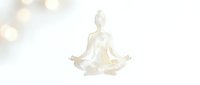 Serene figure in lotus meditation pose with glowing golden light effect, isolated on white background for wellness and mindfulness design projects.