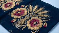 Elegant golden floral embroidery with wheat stalks on dark fabric showcasing traditional needlework craftsmanship for textile and fashion design projects.