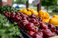 Fresh colorful bell peppers displayed at farmers market stand with red and yellow varieties arranged for healthy organic produce shopping and cooking.