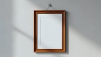 Empty wooden picture frame hanging on white wall with natural shadow lighting for mockup and interior design projects.