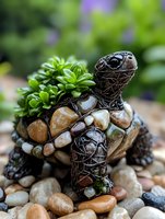 Decorative garden turtle sculpture made from wire mesh and natural river stones, with succulent plants growing from shell, placed on pebble ground in outdoor setting.