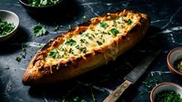Freshly baked garlic bread loaf with herbs and melted butter on dark marble surface, rustic kitchen setting with parsley and seasonings for cooking recipes.