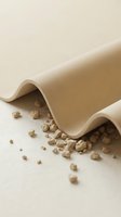 Rolled kraft paper with scattered pebbles on neutral surface, showcasing sustainable packaging materials and natural textures for eco-friendly design projects.