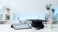 Online learning diploma with graduation cap and light bulb on desk representing distance education achievement and academic success in modern study.