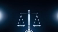 Silver scales of justice balanced on dark background with dramatic lighting for legal and law firm presentations.