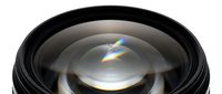 Professional camera lens with rainbow light refraction and optical flare effects isolated on white background for photography equipment and technology concepts.