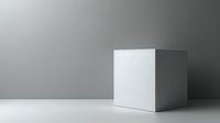 Minimalist white cube on light surface against gradient gray background, perfect for design projects and conceptual presentations. Clean geometric shape with soft shadows.