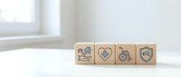 Wooden blocks displaying healthcare and medical insurance icons arranged on clean white surface for business and wellness concepts.