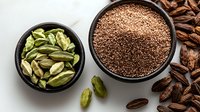 Aromatic cardamom pods and seeds in black ceramic bowls on white background, whole green pods and ground brown powder with scattered spices.