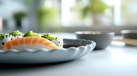 Fresh salmon sushi with rice and broccoli served on elegant white plate in bright kitchen setting with natural light.