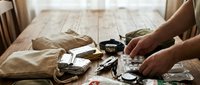 Male hands preparing traditional tea ceremony with vintage teapot and cups on rustic wooden table in warm natural lighting for mindful relaxation ritual.