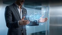 Professional businessman in suit presenting digital technology concepts with holographic interface and data visualization in modern office environment.