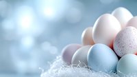 Fresh pastel chicken eggs in soft blue and pink colors arranged on white straw nest with dreamy bokeh background and copy space for Easter design.