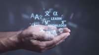 Male hands holding glowing educational symbols and text including learn and knowledge against dark background for online learning, e-learning, training, and education concepts.