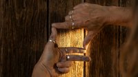 Hands framing warm golden light beam on rustic wooden background creating protective gesture for hope and inspiration concepts.
