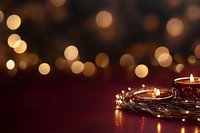 Warm golden bokeh lights with glowing candles and fairy lights creating festive holiday atmosphere on dark burgundy background for celebrations.