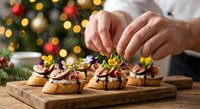 Hands decorating festive chocolate dessert canapes with yellow flowers on wooden board. Christmas holiday baking and culinary presentation concept.