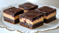 Decadent layered chocolate dessert bars with creamy filling and glossy ganache topping on white plate for bakery menu and sweet treat advertising.