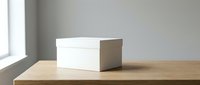 White cardboard box on wooden table near window with natural light. Clean minimalist packaging mockup for branding and product presentation.