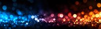 Colorful bokeh lights panorama with blue, red, and orange glowing particles on dark background. Abstract defocused illumination effect.