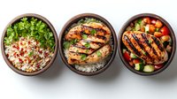 Grilled chicken rice bowls with fresh vegetables and herbs served in brown ceramic bowls, featuring different toppings and seasonings for healthy meal prep options.