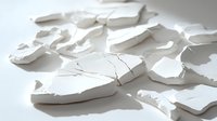 Broken white ceramic fragments scattered on light surface creating abstract composition with dramatic shadows. Artistic still life for design projects.