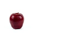 Fresh red apple with glossy skin isolated on white background for healthy eating and nutrition concepts.