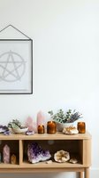 Wooden shelf with crystal clusters, dried lavender, amber glass bottles, and pentagram wall art for spiritual home decor and wellness styling.