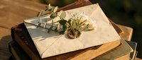 Vintage love letter with dried flowers on old books creating romantic nostalgic atmosphere for wedding invitations and greeting cards.