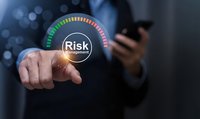Businessman touching glowing risk management gauge interface, holding smartphone, dark background, business strategy concept.