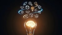 Glowing lightbulb with brain inside surrounded by floating business and innovation icons on dark background representing creativity and ideas.